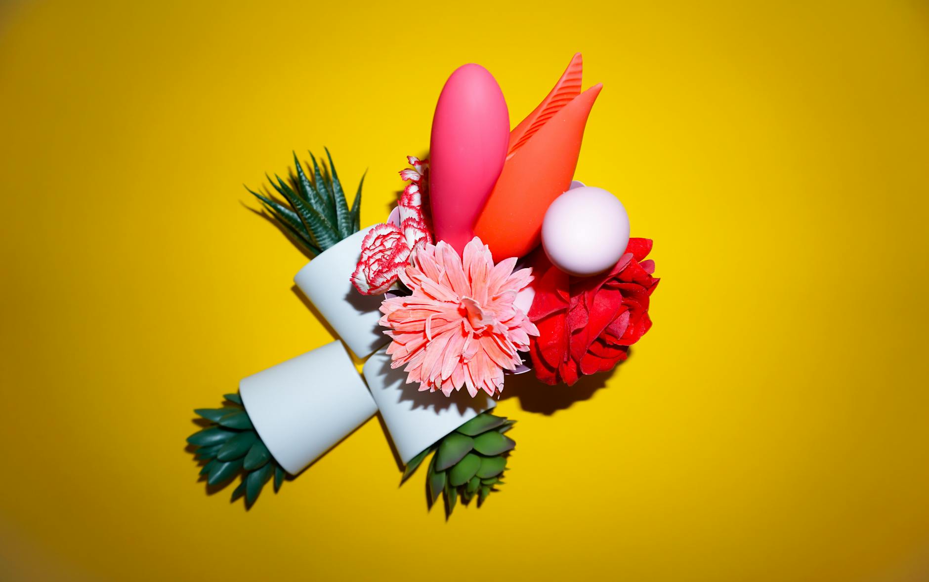Colorful vibrators arranged on a bright yellow background, showcasing various toy designs.